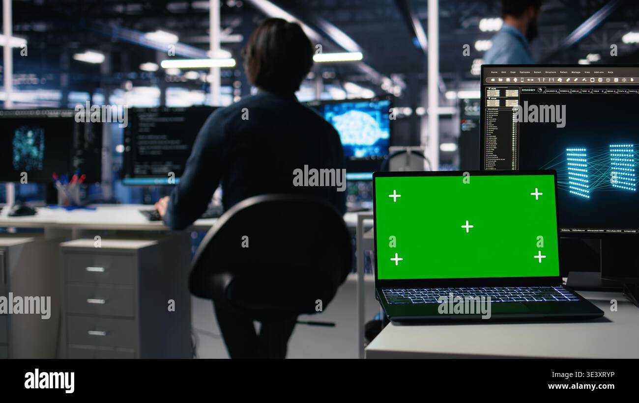 Data center engineer working on neural network software development on chroma key laptop. Server room IT specialist implementing machine learning technology using isolated screen notebook, camera A Stock Photo