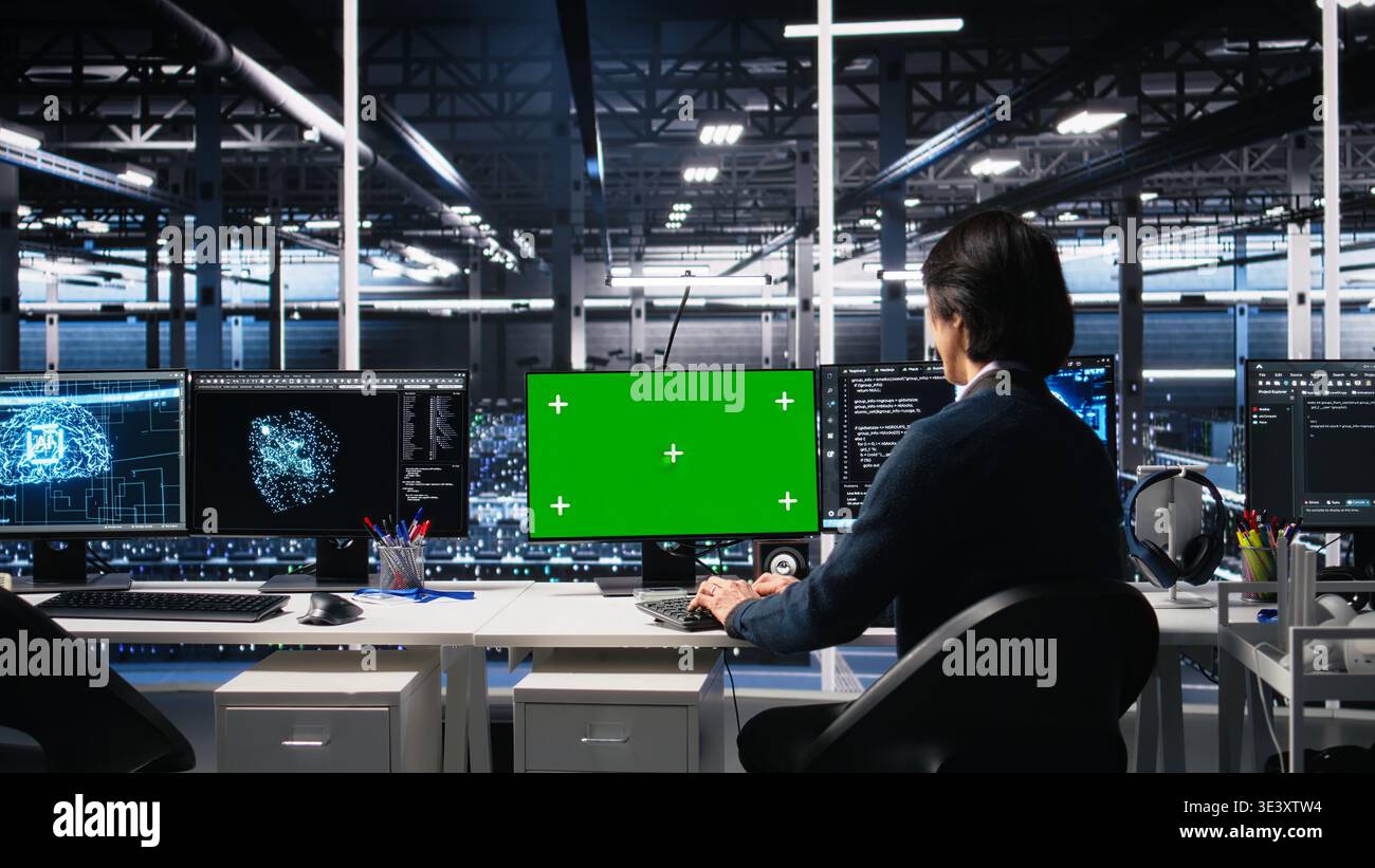 Data center technician uses machine learning algorithms on isolated screen PC to analyze datasets. Server hub worker uses AI neural networks on chroma key computer to recognize data patterns, camera A Stock Photo