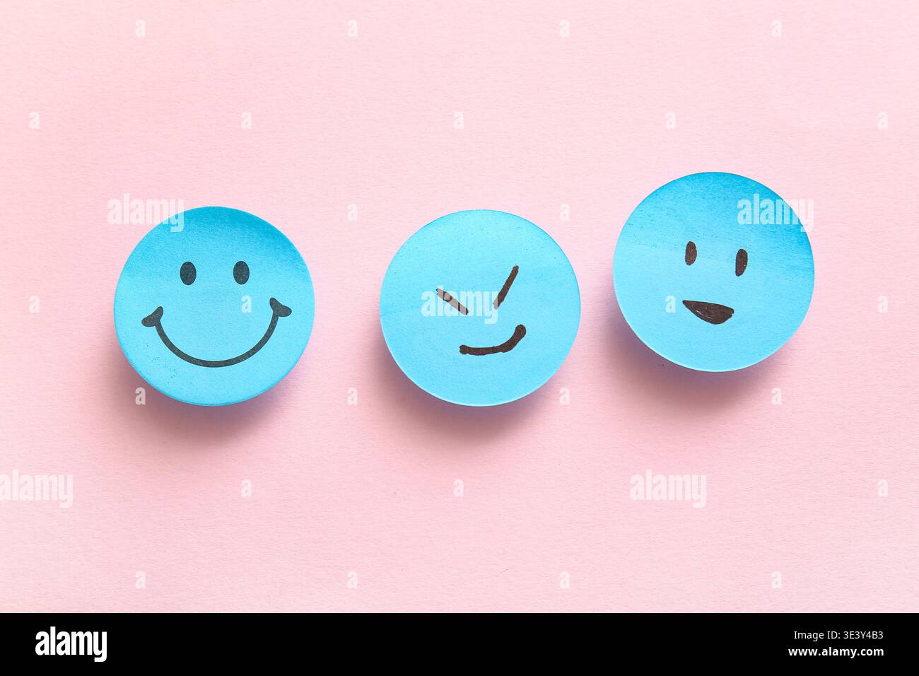 Sticky notes with smiley faces on pink background Stock Photo