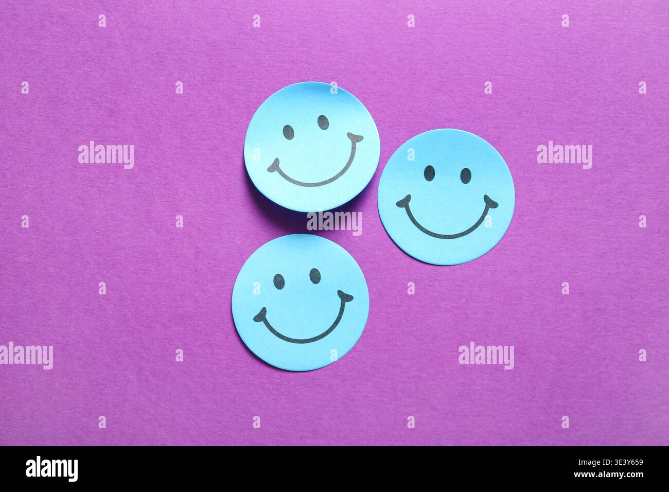 Sticky notes with smiley faces on purple background Stock Photo
