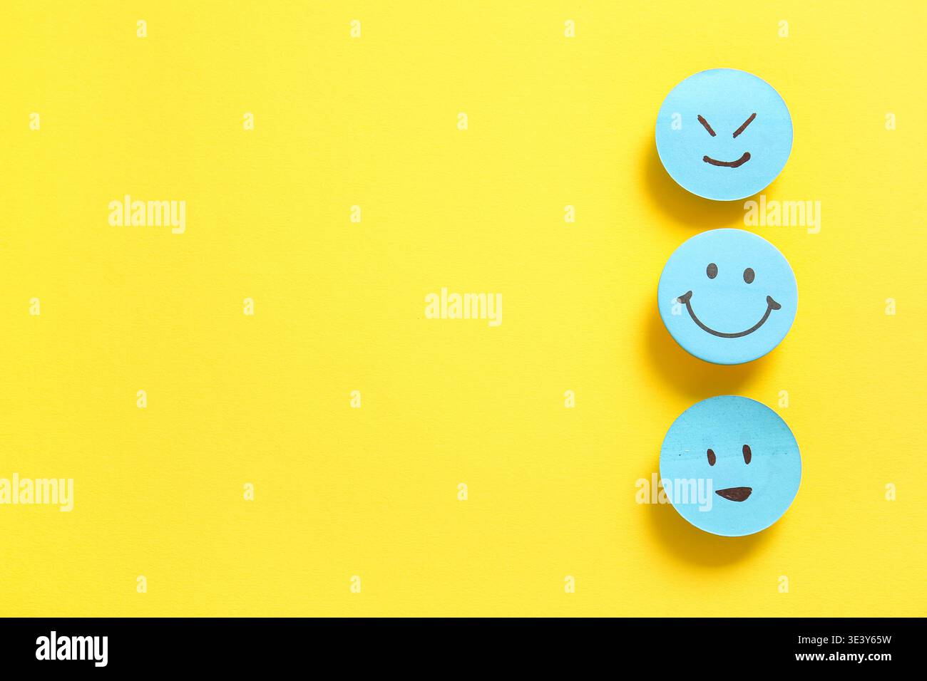 Sticky notes with smiley faces on yellow background Stock Photo