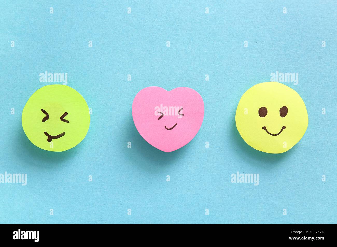 Sticky notes with smiley faces on blue background Stock Photo