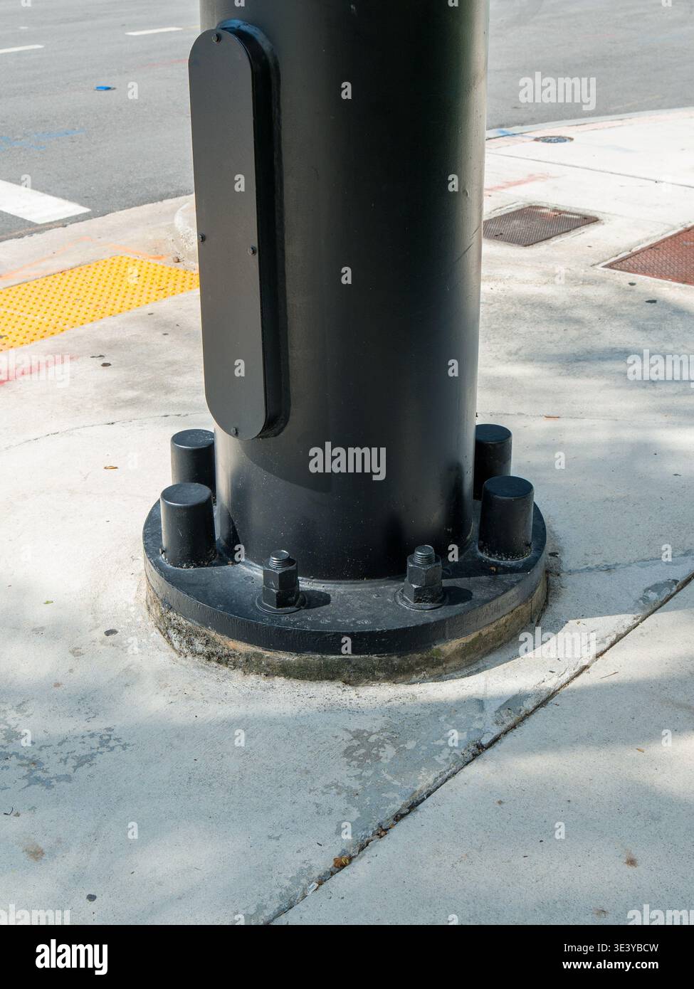 The industrial utility post foundation is anchored to a paved walkway ...