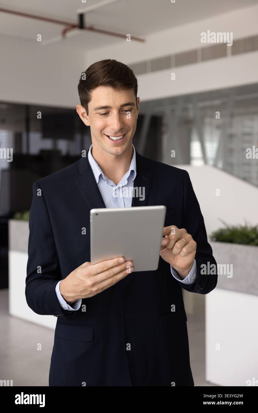 Professional man smiling and using digital tablet in office Stock Photo