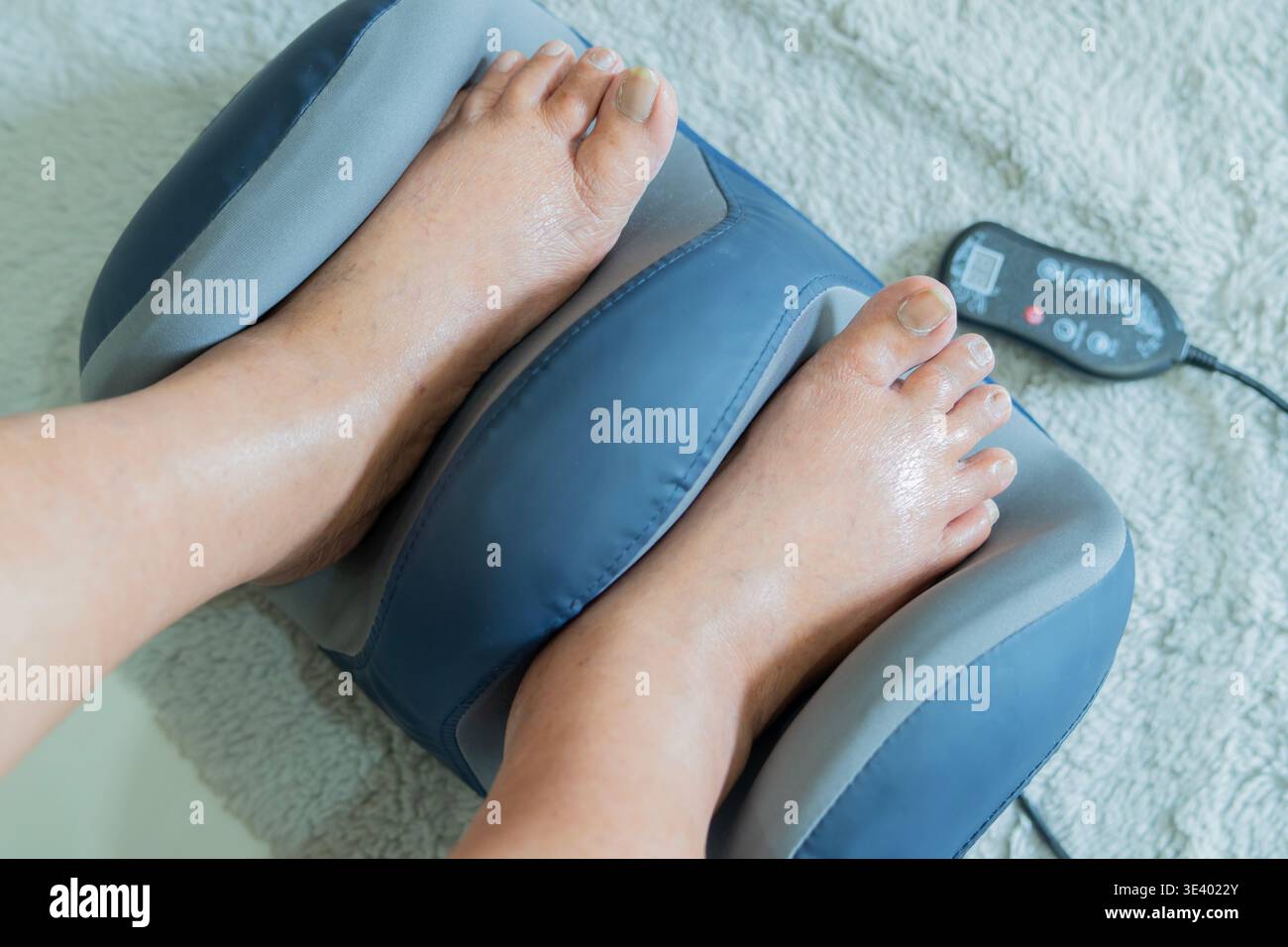 Relaxing elderly foot massage at home with electric foot massager for pain  relief and foot care therapy tool. Electric vibrating feet massager Stock  Photo - Alamy