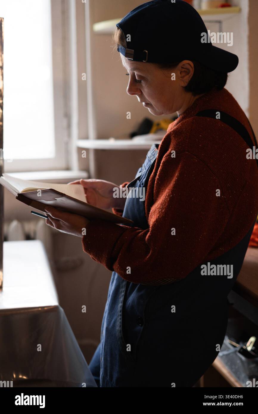 Female repairman writing notes while working in workshop. DIY concept. copy space Stock Photo