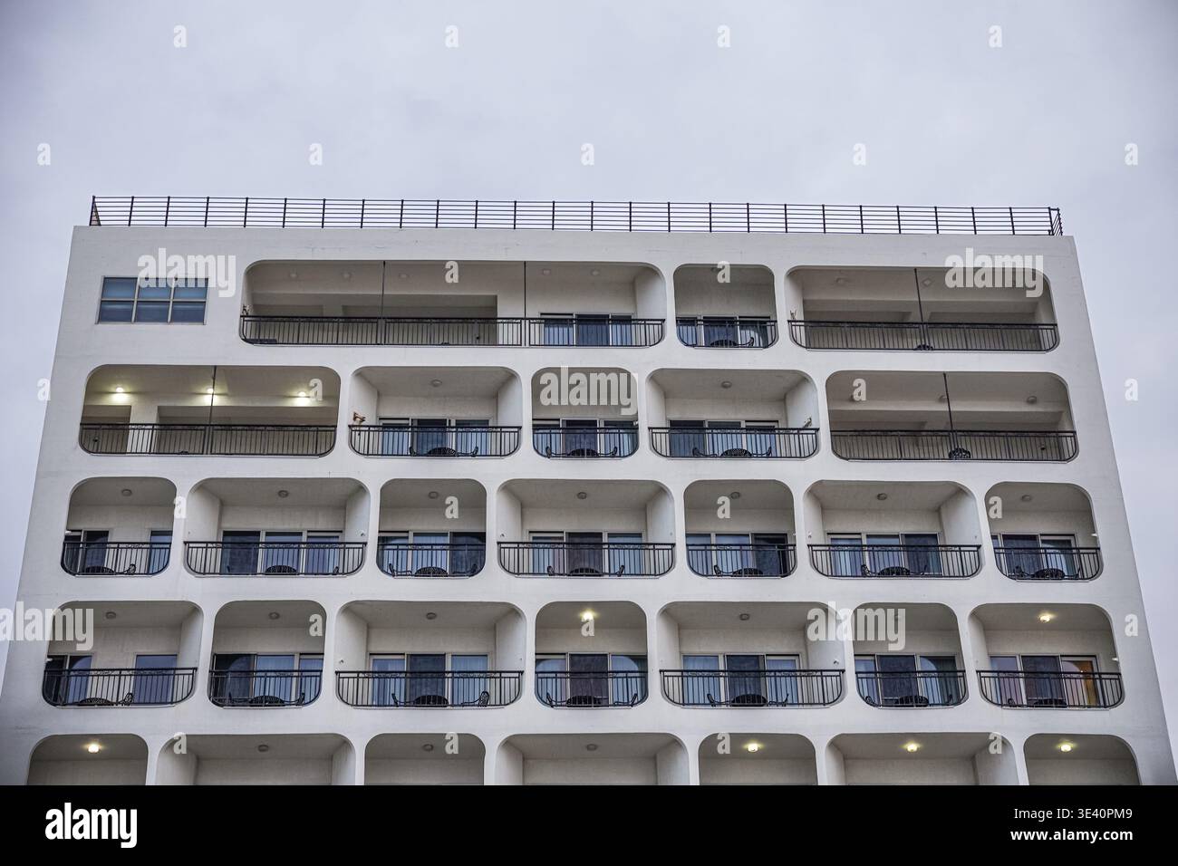 White Modern Apartment Building Facade with Repeating Balconies Stock Photo
