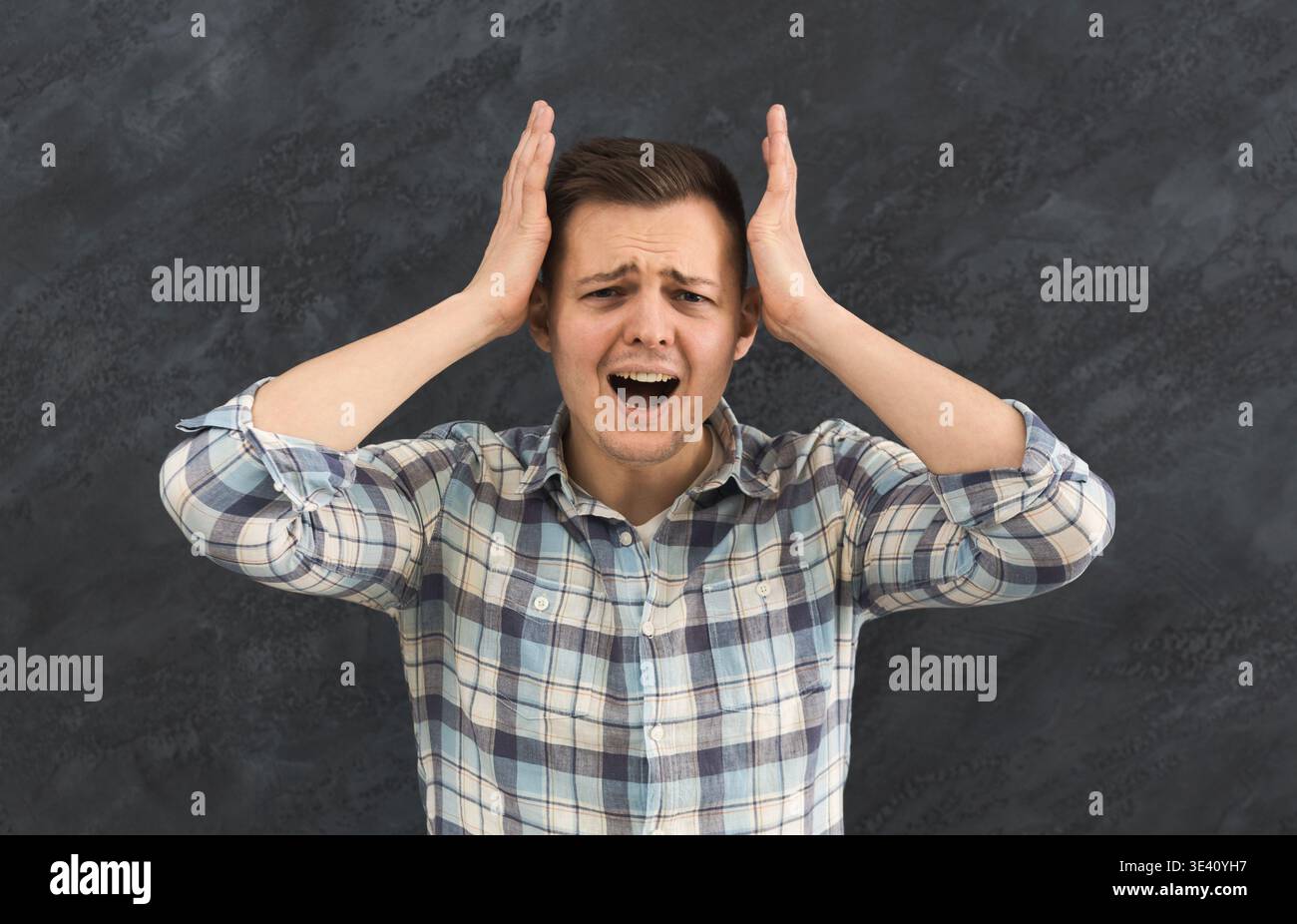 Irritated young man in stress screaming loudly Stock Photo