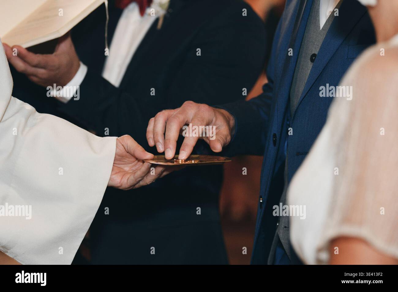 Presenting A Ritual Priest presenting wedding rings on paten during sacred church ritual ...
