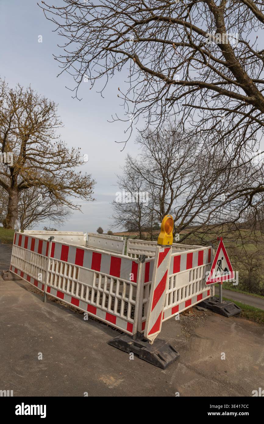 Road works warning sign and safety barrier at construction site on ...