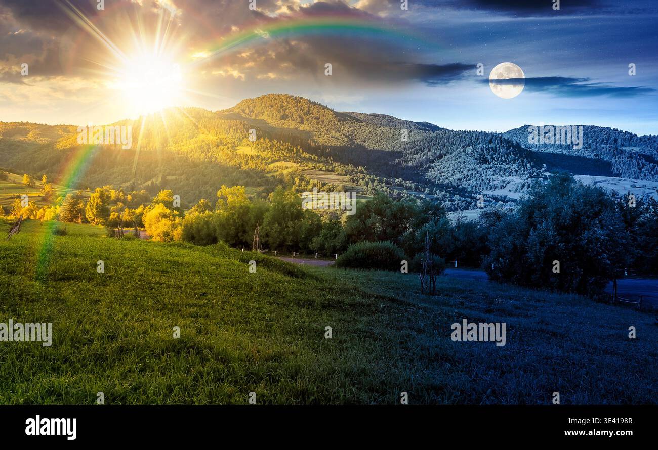 agricultural grassy field and rolling hills in mountainous rural scenery in summertime. day meet night. sun and moon over wonderful countryside landsc Stock Photo