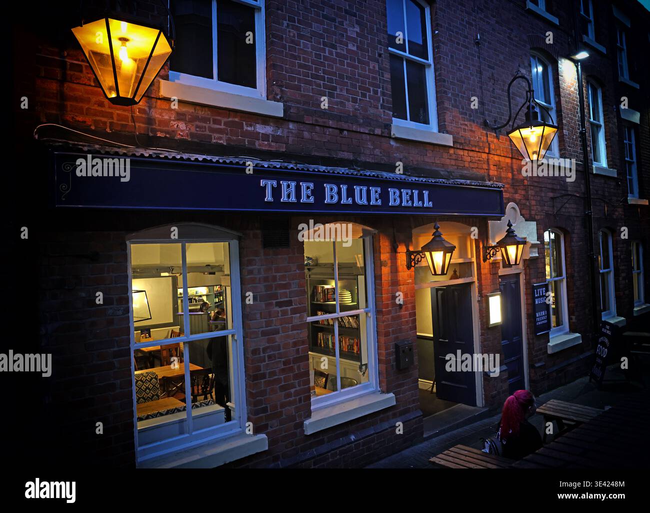 The Blue Bell pub at dusk on Horsemarket Street, Warrington, lit for the evening and reflecting the town centre night-time economy. Stock Photo