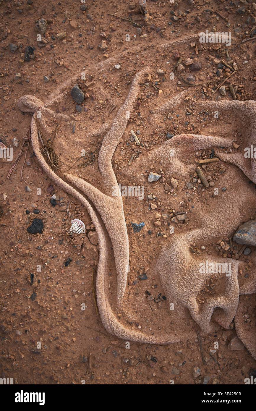 Abandoned Towel on Nevada Desert Ground with Rocks and Debris Close Up Stock Photo