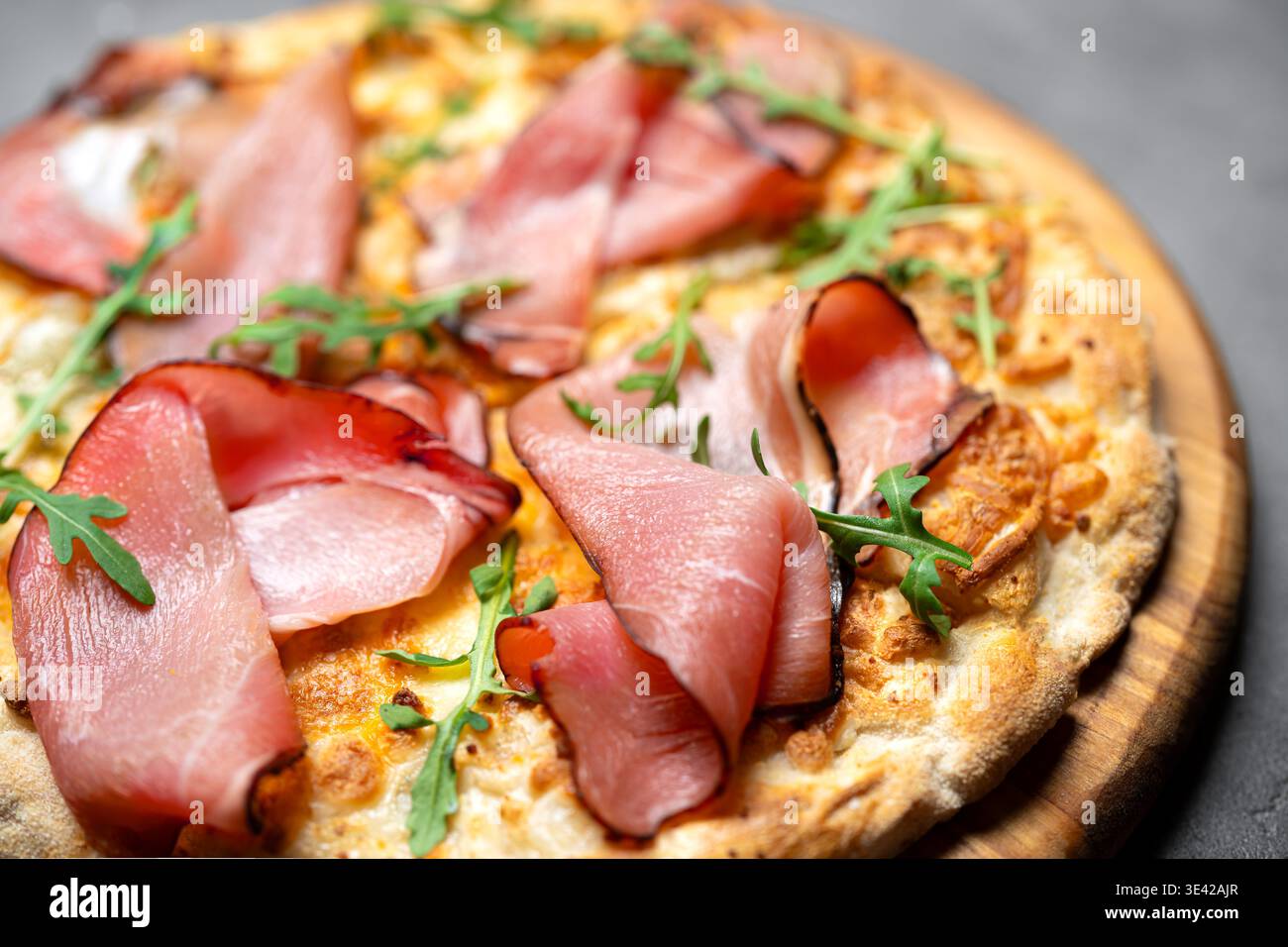 Prosciutto Pizza or Jamon Pizza extremely detailed and close up. Classic italian whole prosciutto and gorgonzola cheese pizza with arugula. Stock Photo