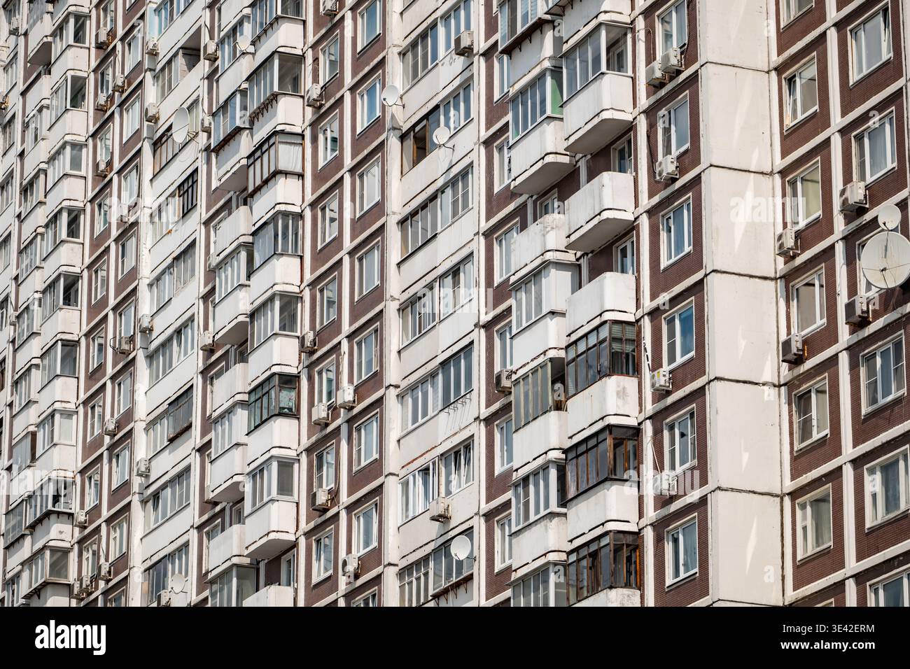 Soviet apartment building facade featuring repeating windows and balconies pattern Stock Photo