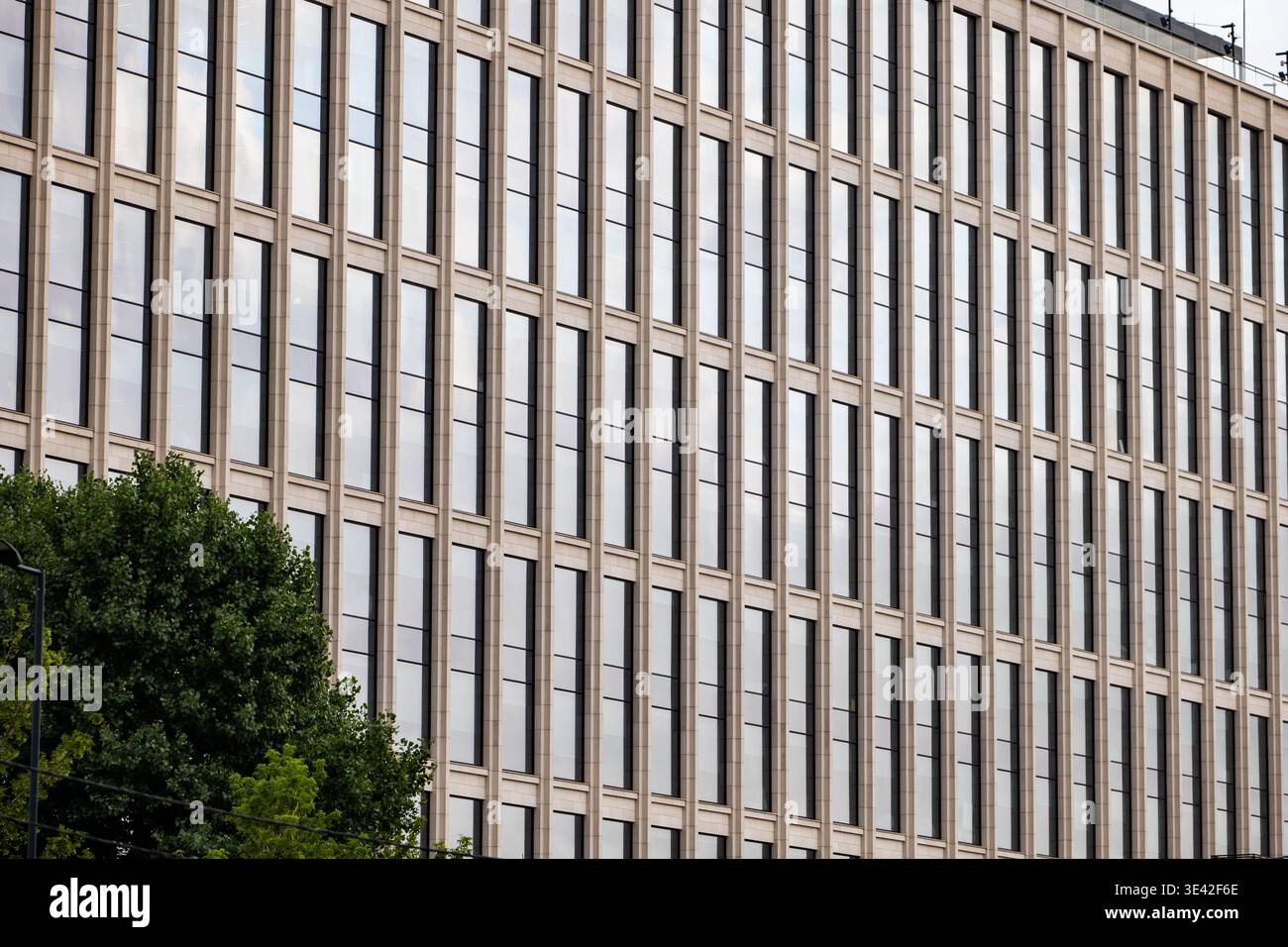 Modern corporate building facade with repeating windows and classic architectural elements Stock Photo