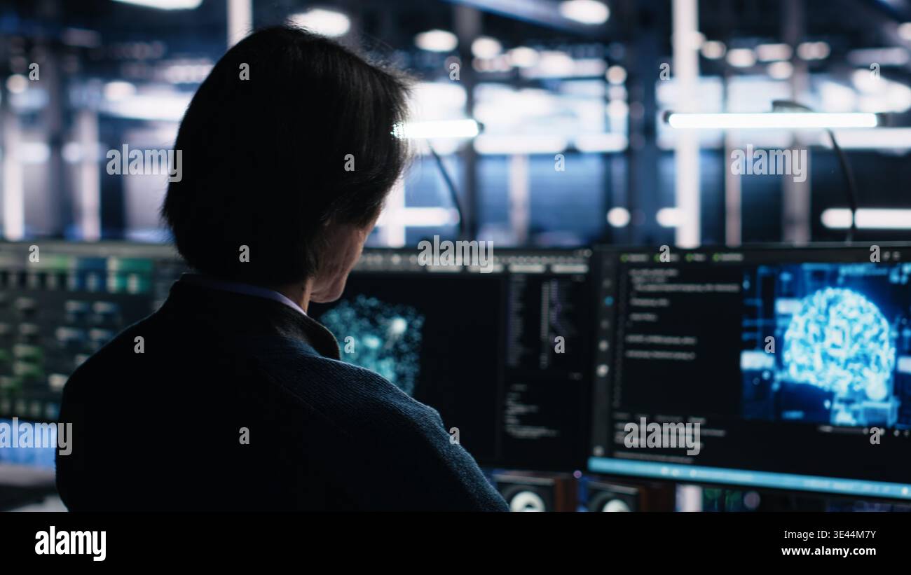 Data center system administrator working on artificial intelligence neural network software development. Server room IT specialist implementing machine learning technology in workplace, camera A Stock Photo
