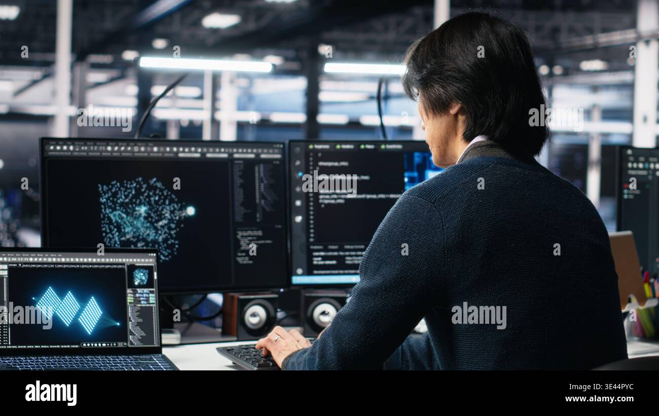 Admin entering data center office, reviews AI diagnostics on computer. IT expert starting work at server farm desk, optimizing artificial intelligence systems configuration, camera A Stock Photo