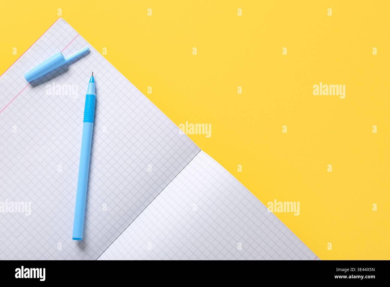 Open notebook with pen on yellow background Stock Photo