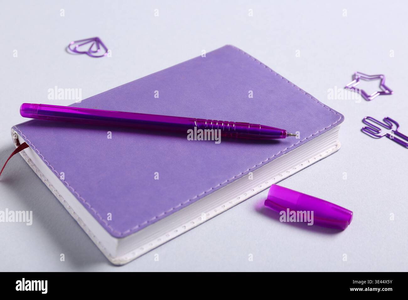 Notebook, pen and paper clips on grey background Stock Photo