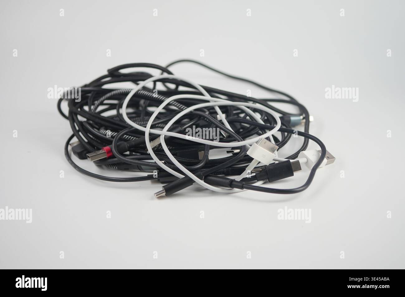 Various tangled cables are scattered on a white background Stock Photo