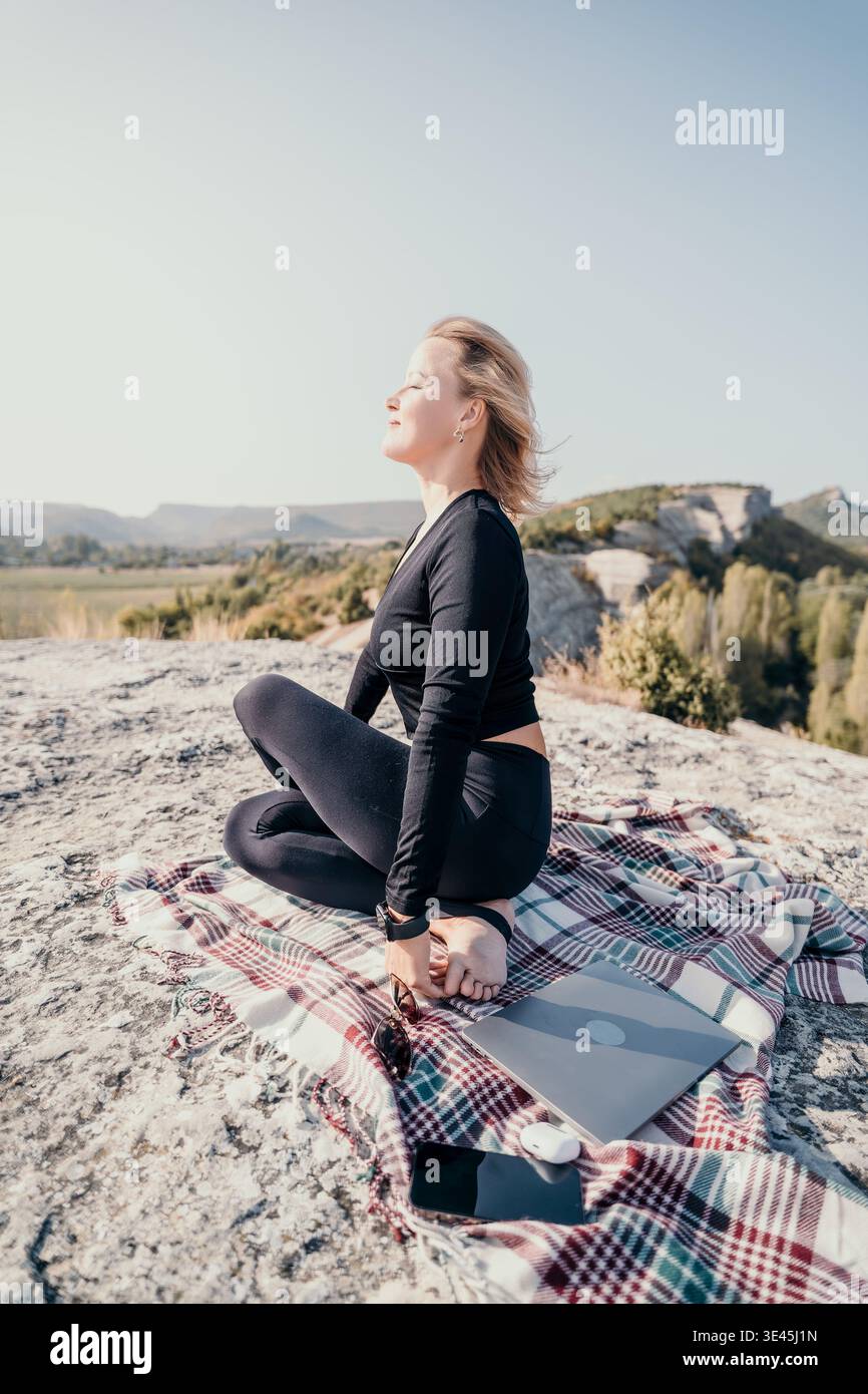 Woman Meditating on a Mountaintop Stock Photo
