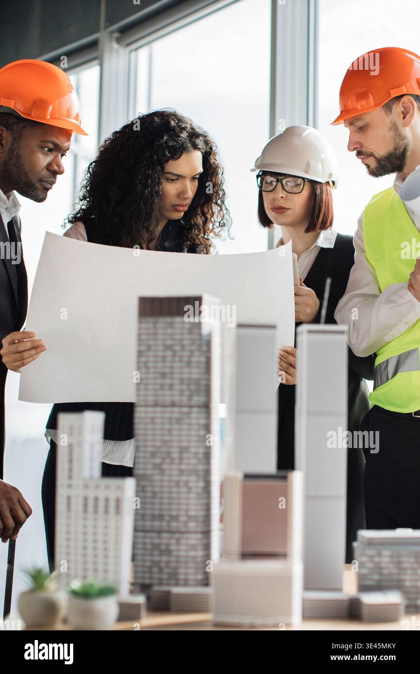 Construction Team Reviewing Blueprints Stock Photo