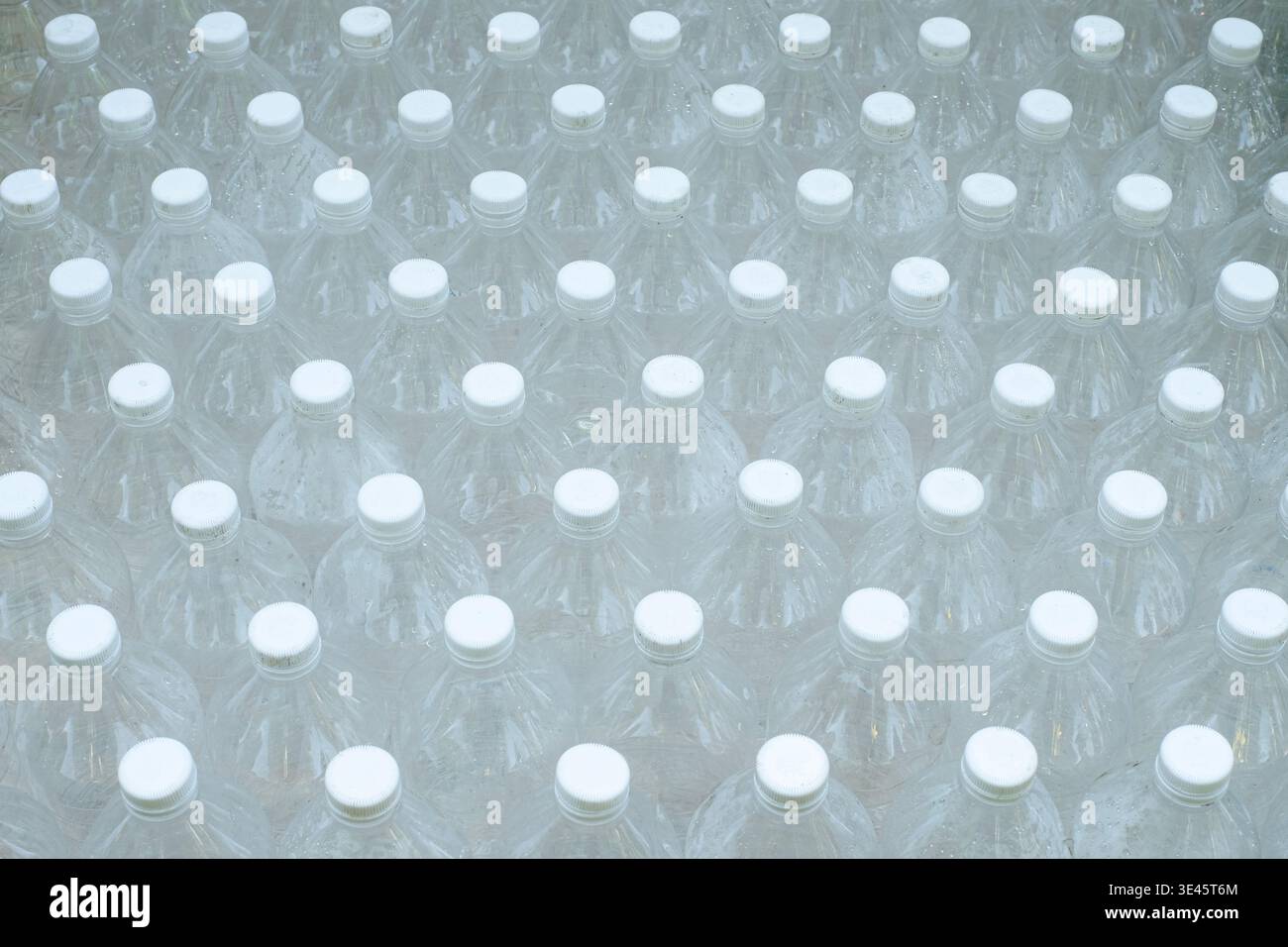 Several empty clear plastic bottles were stacked in a row. Stock Photo