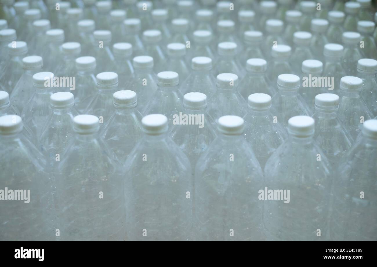Several empty clear plastic bottles were stacked in a row. Stock Photo