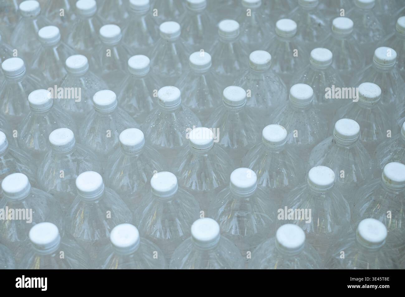 Several empty clear plastic bottles were stacked in a row. Stock Photo