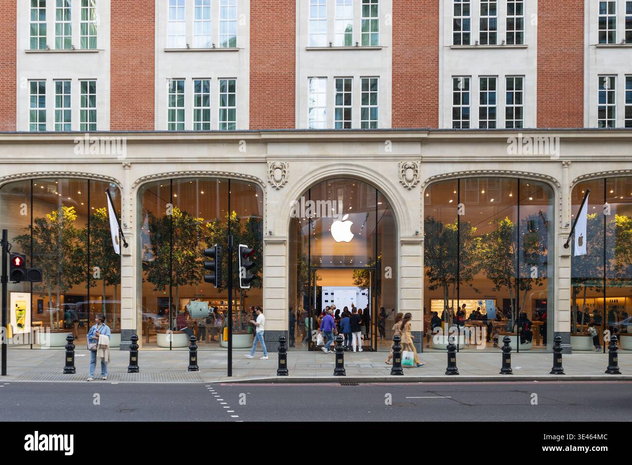Apple store entrance in a historic brick building with shoppers. London, UK, 19 August 2023 Stock Photo