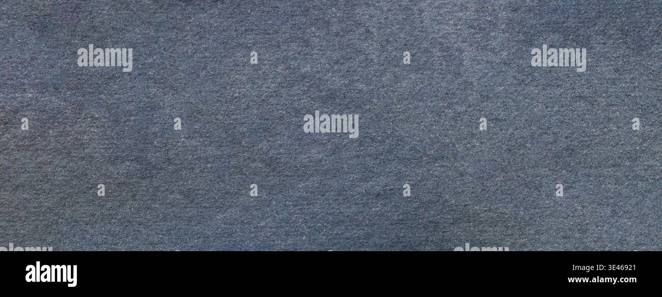 Slate blue textured paper background with subtle grain surface and soft structure. Dark gray backdrop, macro. Stock Photo