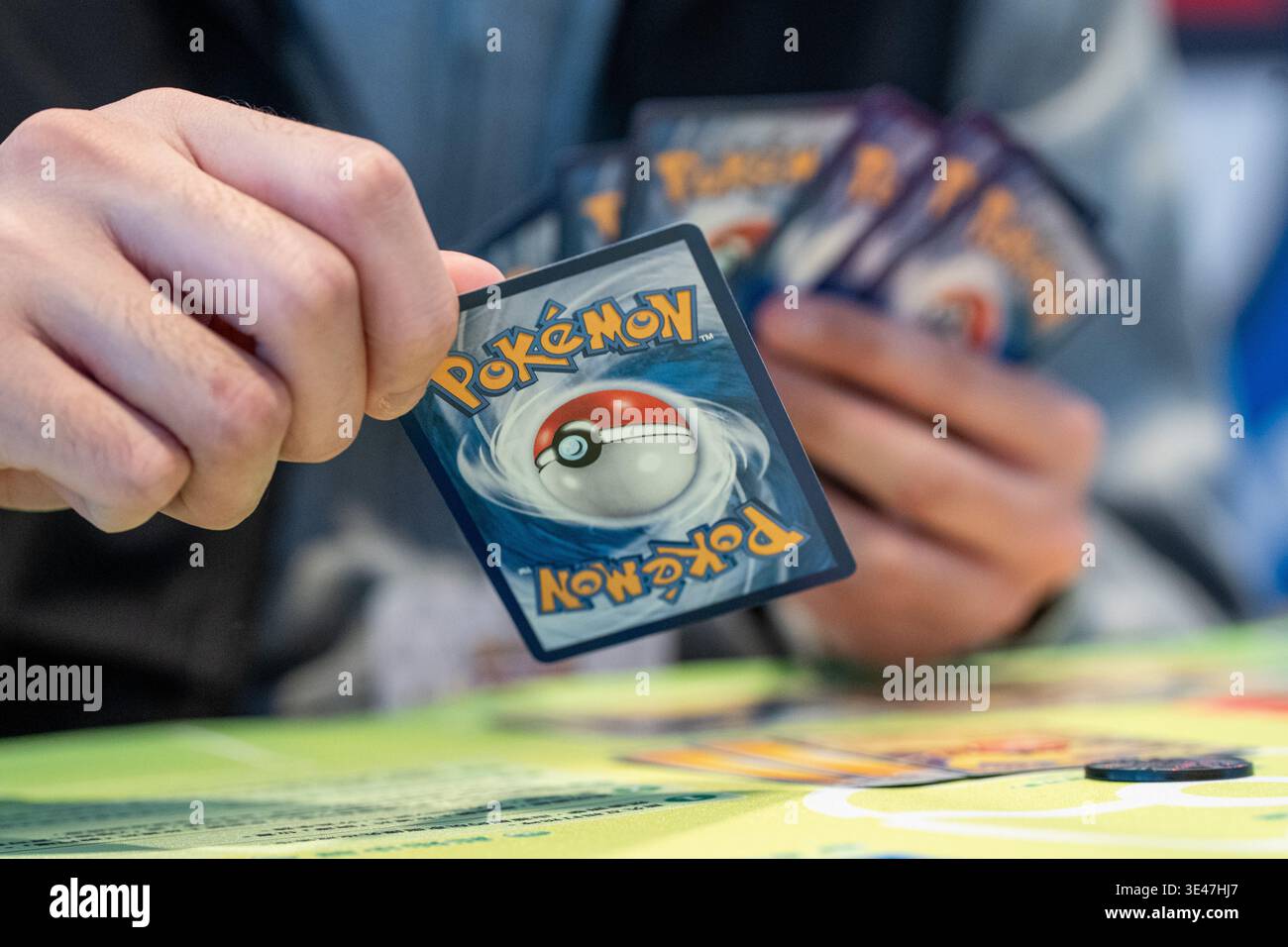 A player holing a stack of Pokmon Trading Card during a Pokemon card game  at a