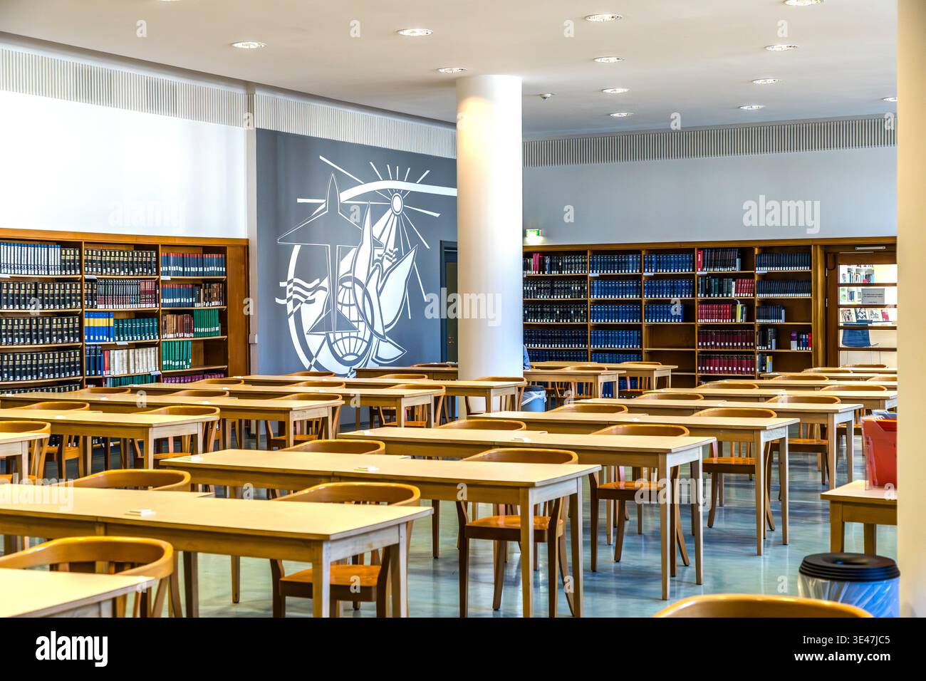 The reading room of the German National Library from the 1960s, featuring angular kidney-shaped tables and wall decorations typical of the GDR. Leipzig, Saxony, Germany Stock Photo