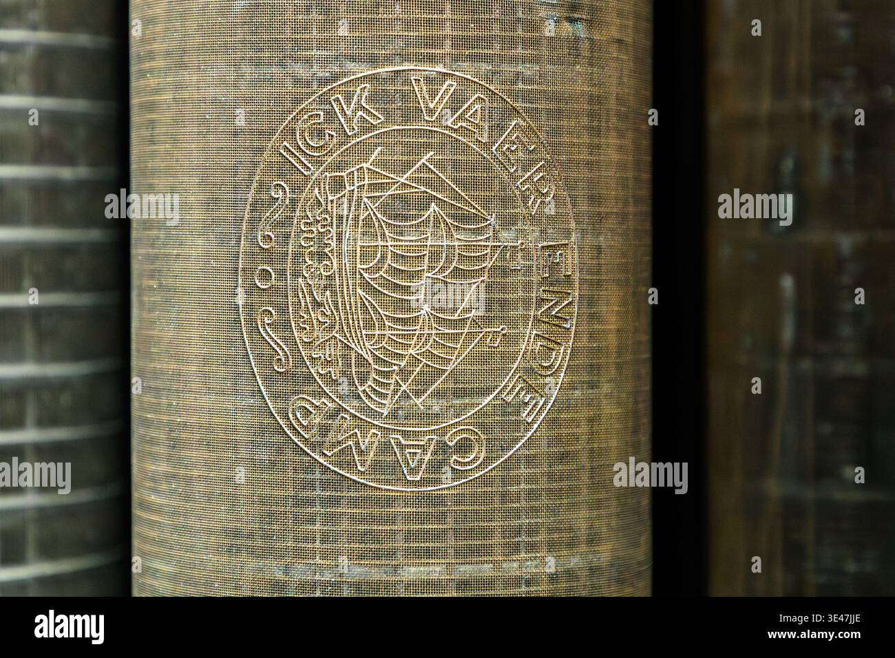 A watermark or sieve roller from a dewatering machine in the collection of the German Book and Writing Museum. Such rollers improve sheet formation and were historically also used to emboss watermarks into the paper. A circular emblem bearing the inscription "ICK VAER ENDE CAMP" and a sailing ship can be seen. Leipzig, Saxony, Germany Stock Photo