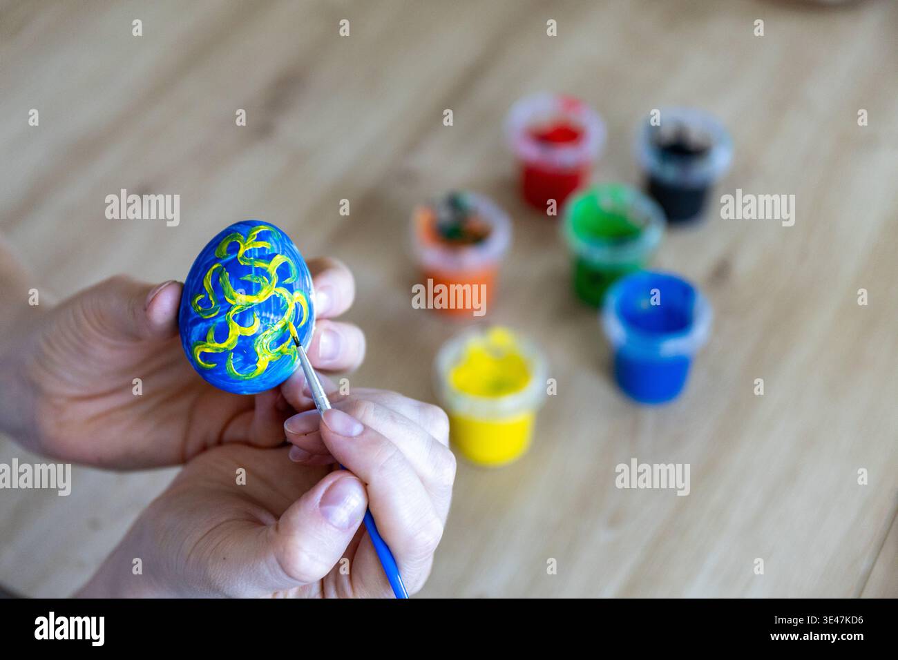 Woman is painting eggs preparing for Easter.  Stock Photo