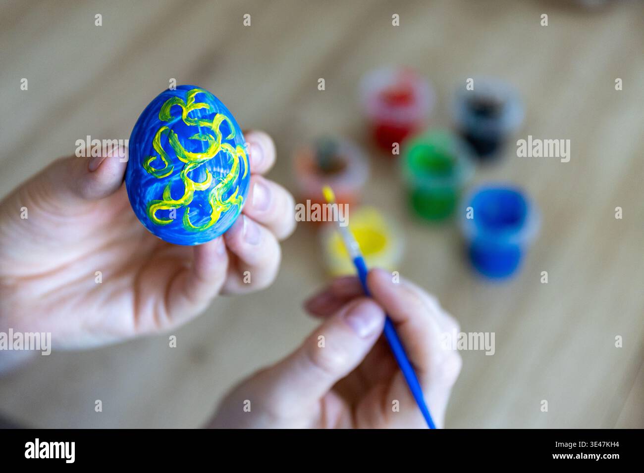 Woman is painting eggs preparing for Easter.  Stock Photo