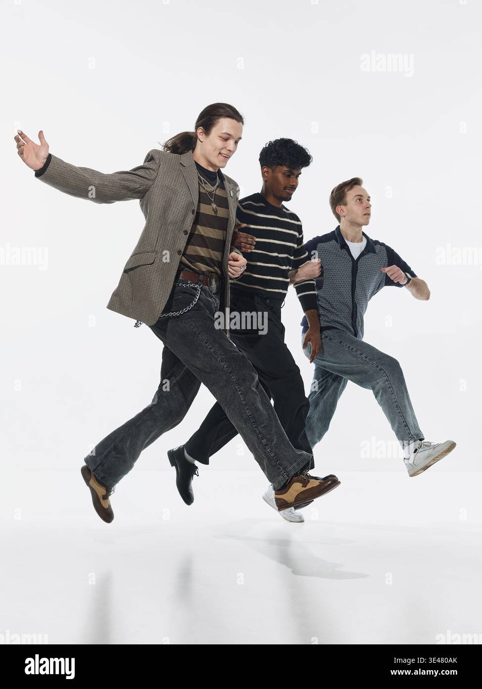 Three men walking in synchronized motion isolated on white background. Stock Photo