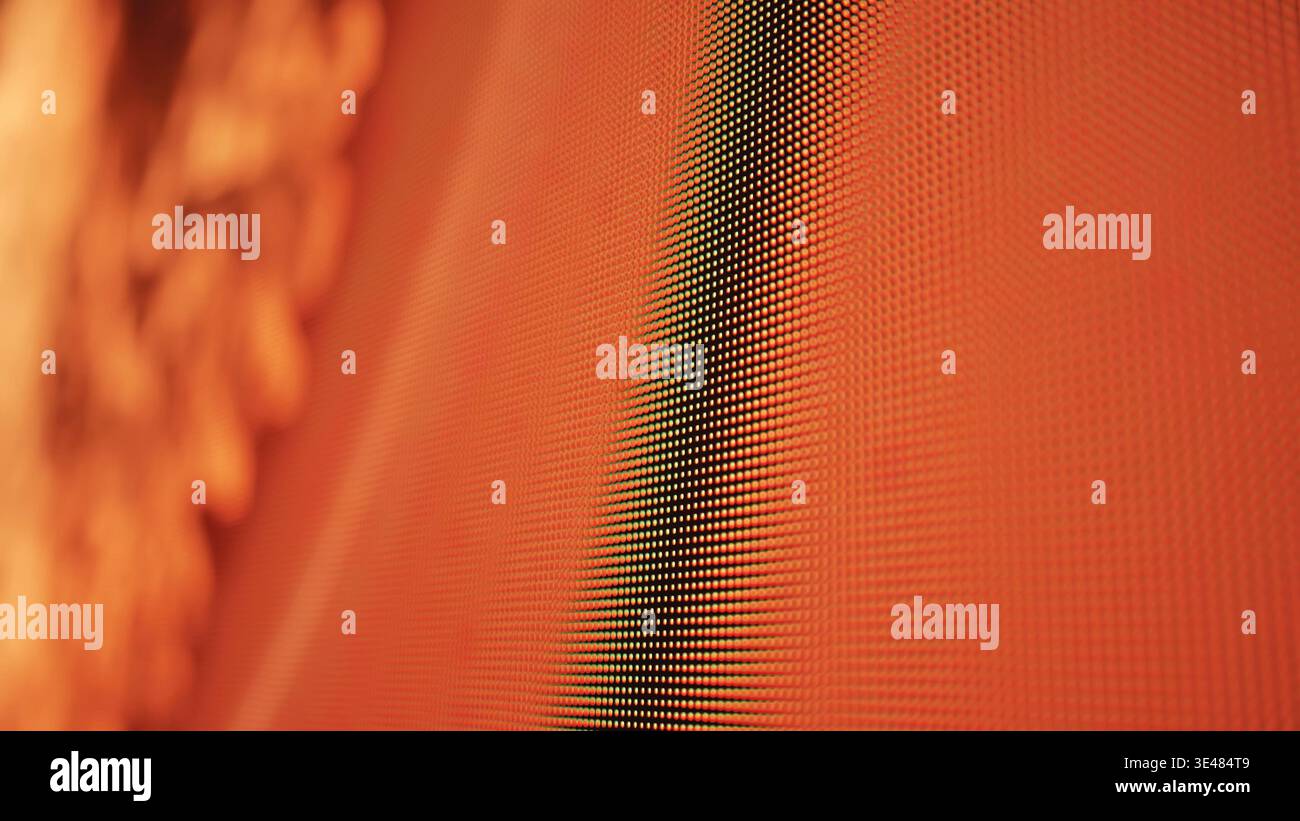 LED screen pixels creating modern digital display with abstract orange red light Stock Photo