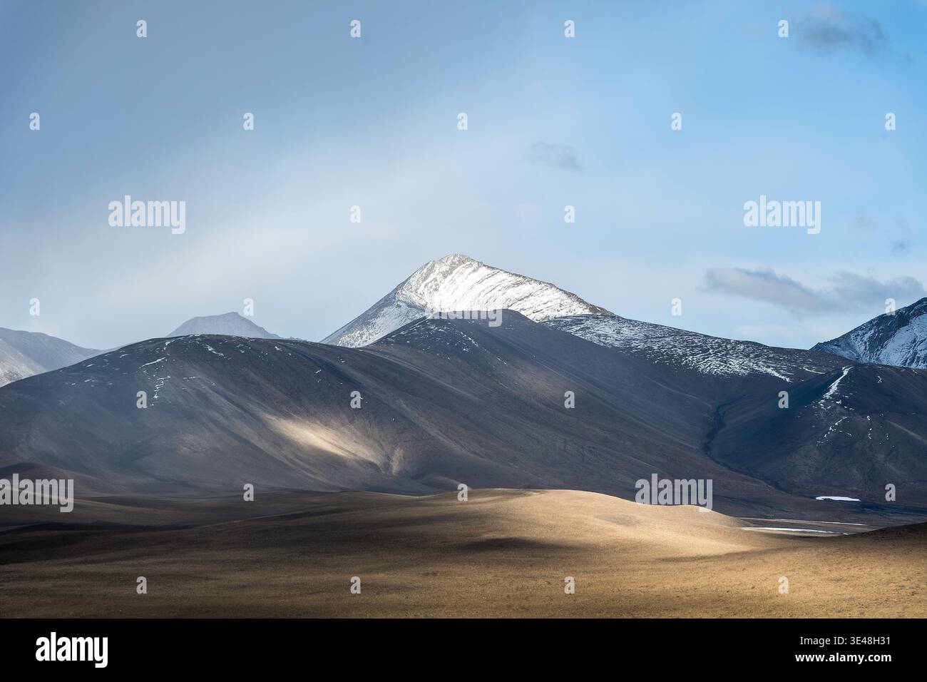 snowy peak in an sunlighted mountain range Stock Photo