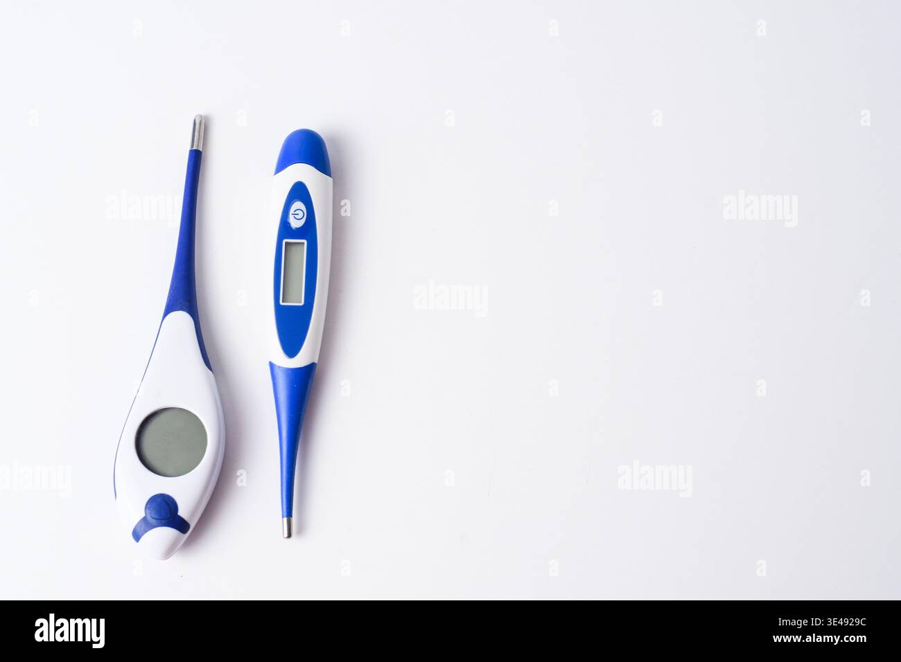 Two digital thermometers on white background with copy space, home healthcare and fever measurement concept. Stock Photo