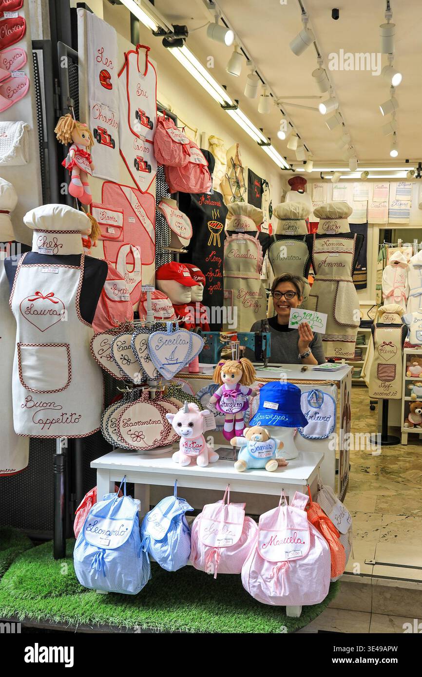 A woman in her shop selling hand stitched goods with personalised names on them, Taormina, Sicily, Italy, Europe Stock Photo