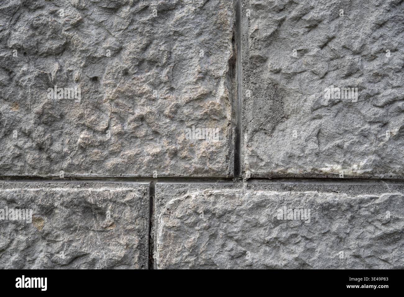 Rough gray stone wall background showing textured masonry block surface Stock Photo