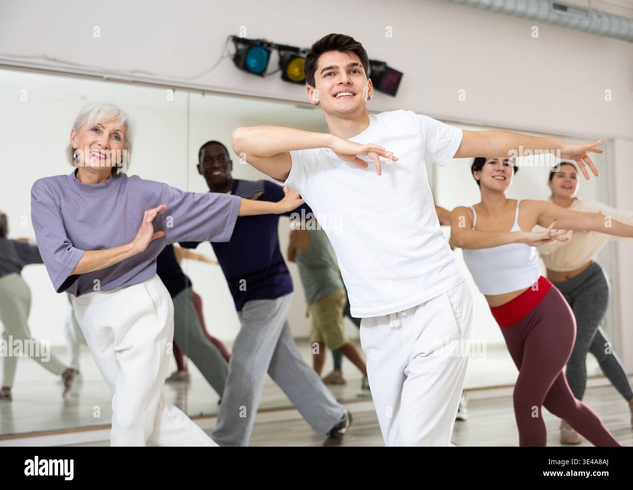 Cheerful guy practicing modern vigorous dance with group Stock Photo