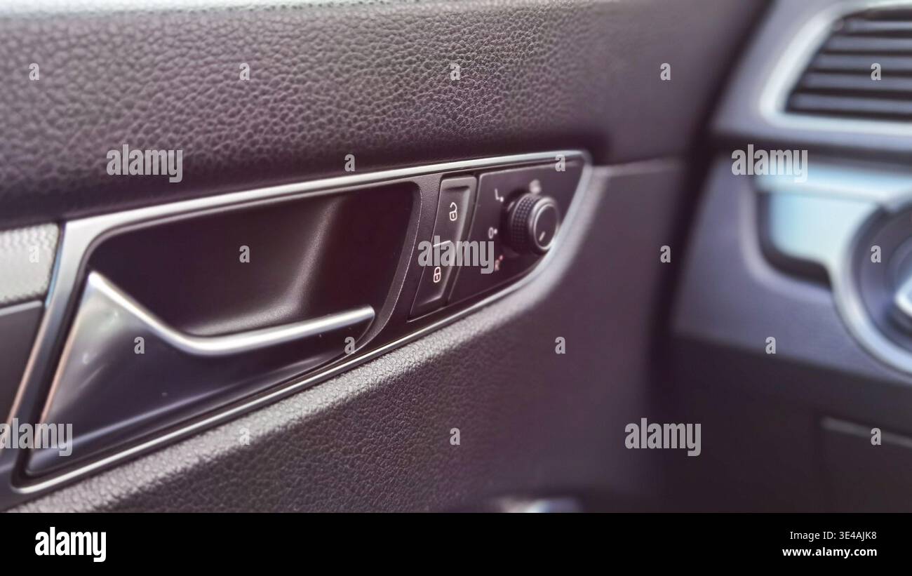 Car Door Interior Handle Lock and Mirror Control Close Up Stock Photo