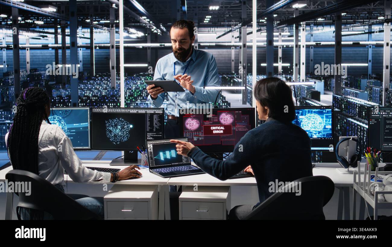 System administrators in data center struggle with computer bugs while using AI. Frustrated server farm coworkers doing brainstorming to fix system errors while using artificial intelligence, camera A Stock Photo