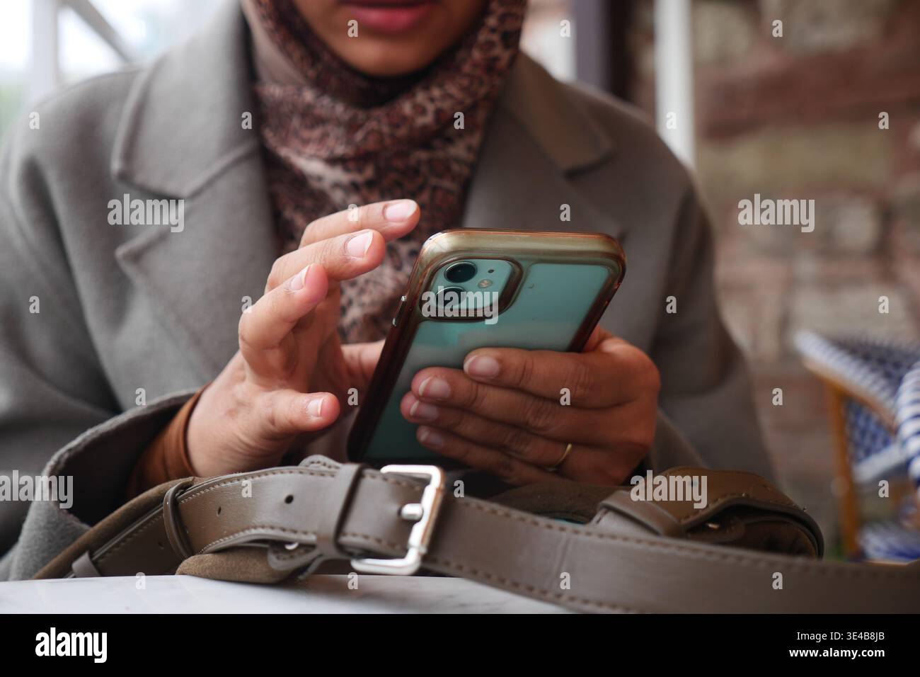 Woman using smartphone at a cafe in a city Stock Photo