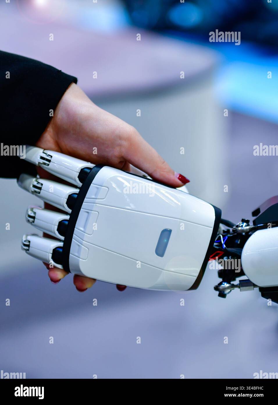 Advanced bionic robotic hand shaking hands with human, symbolizing AI and human collaboration. Stock Photo