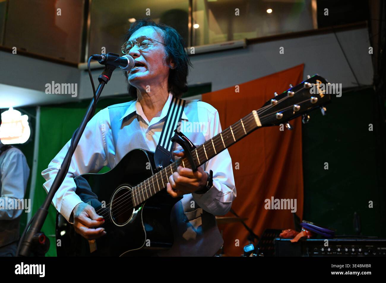 "John Lennon" performs live with the tribute band The Bangkok Beatles in Hua Hin, Thailand. Stock Photo