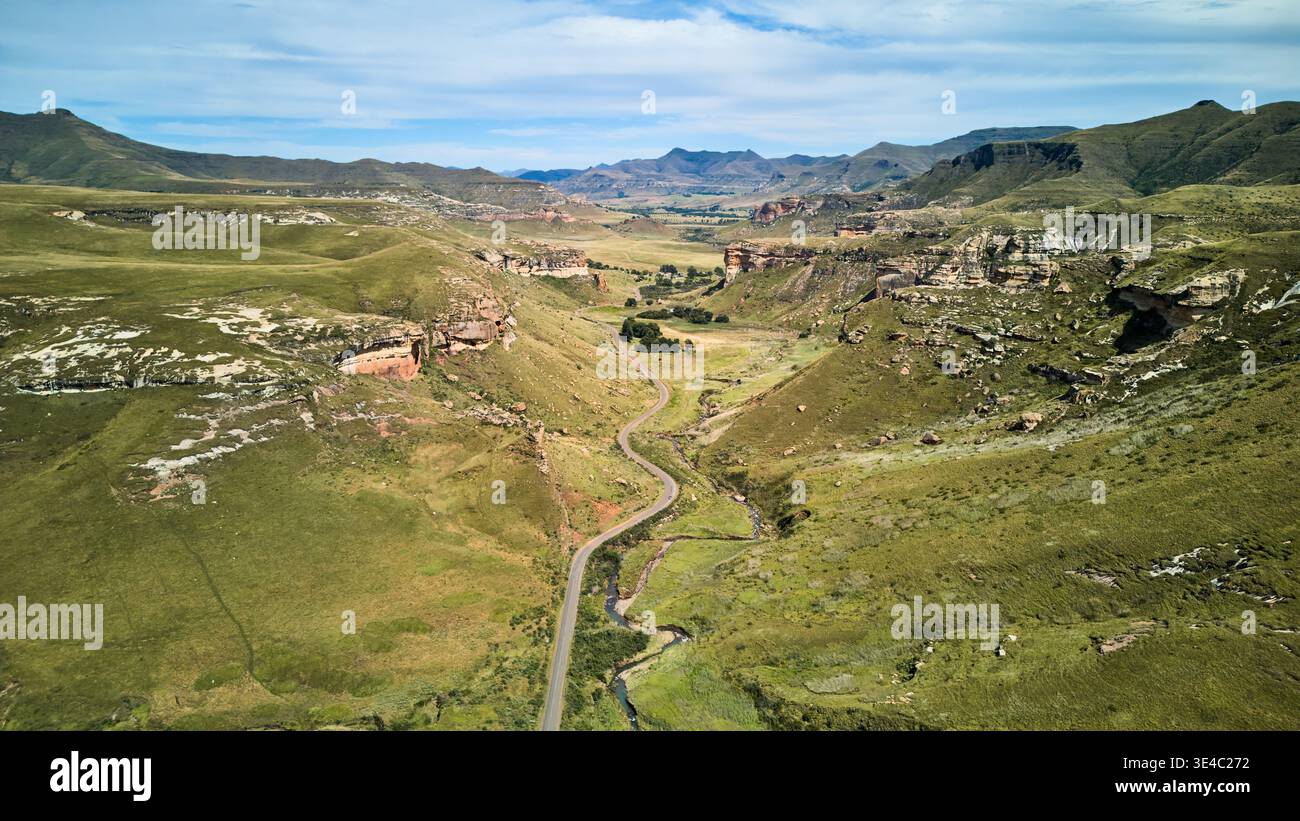 Wide Scenic Landscape. Peaceful Valley Stretching With Narrow Road Amidst Open Fields And Gentle Hills Stock Photo